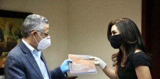 Claudia Franchesca de los Santos entrega un ejemplar de los planes para la solución de movilidad de Santo Domingo Este a Manuel Jiménez, alcalde de ese municipio.