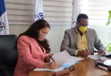La directora de la ADESS, Digna Reynoso y el titular de Pro Consumidor, Eddy Alcántara, firman el acuerdo.