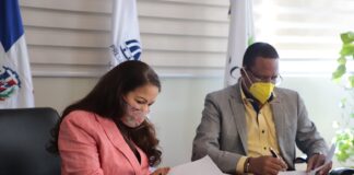 La directora de la ADESS, Digna Reynoso y el titular de Pro Consumidor, Eddy Alcántara, firman el acuerdo.